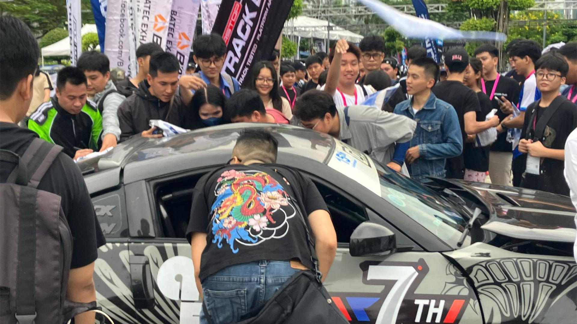 Crowd stands around a racing car