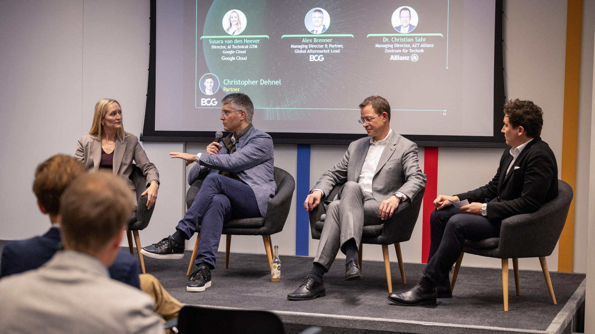 Podiumsdiskussion mit vier Fachleuten auf einer Konferenzbühne vor Publikum