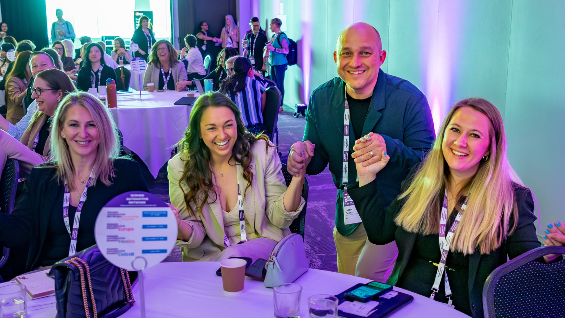 Drei Frauen und ein Mann an einem Tisch des Women Automotive Network Summit