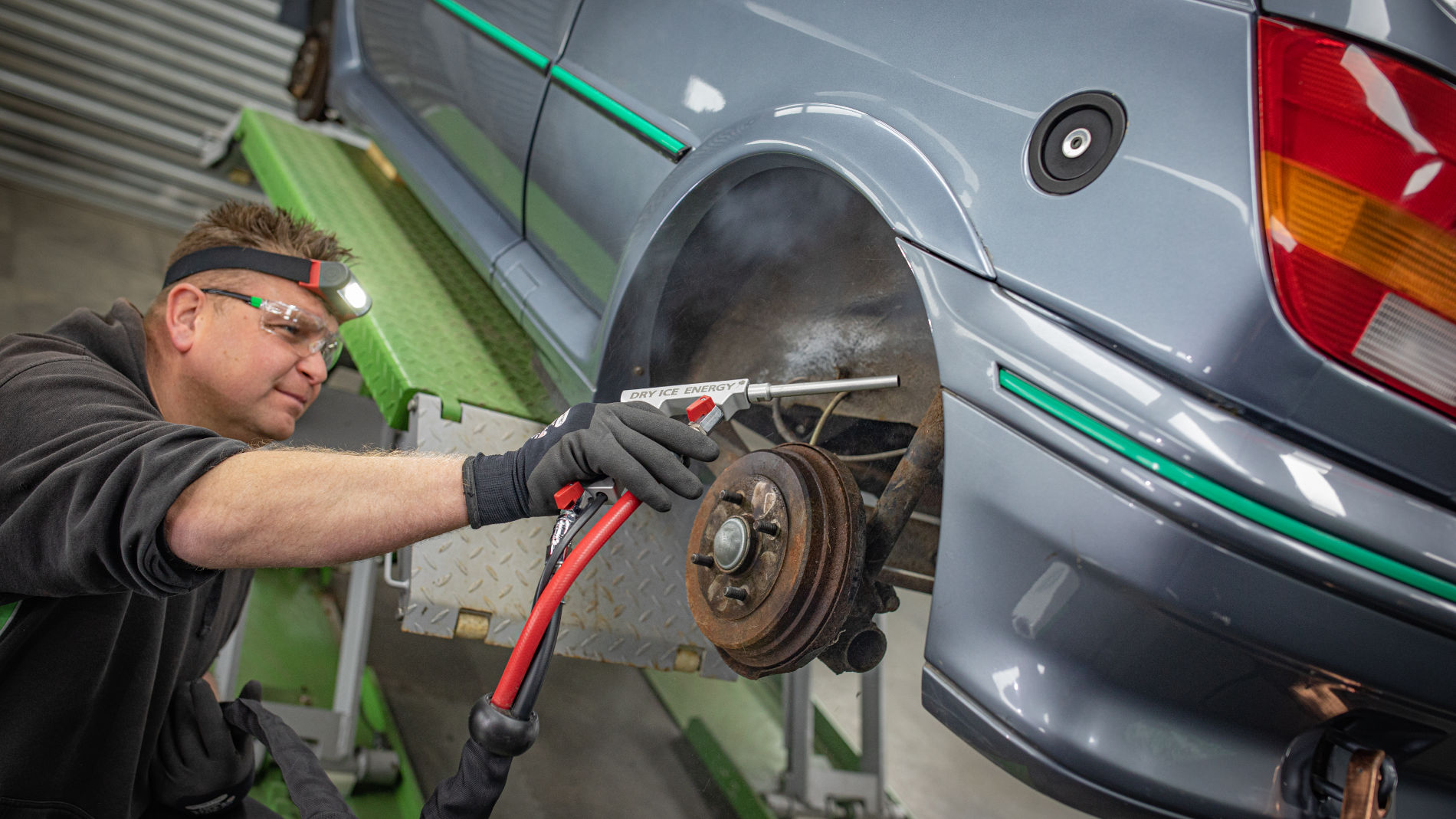 Fachmann reinigt ein Fahrzeug mit Trockeneisstrahler – innovative und umweltschonende Methode in der Autoaufbereitung.