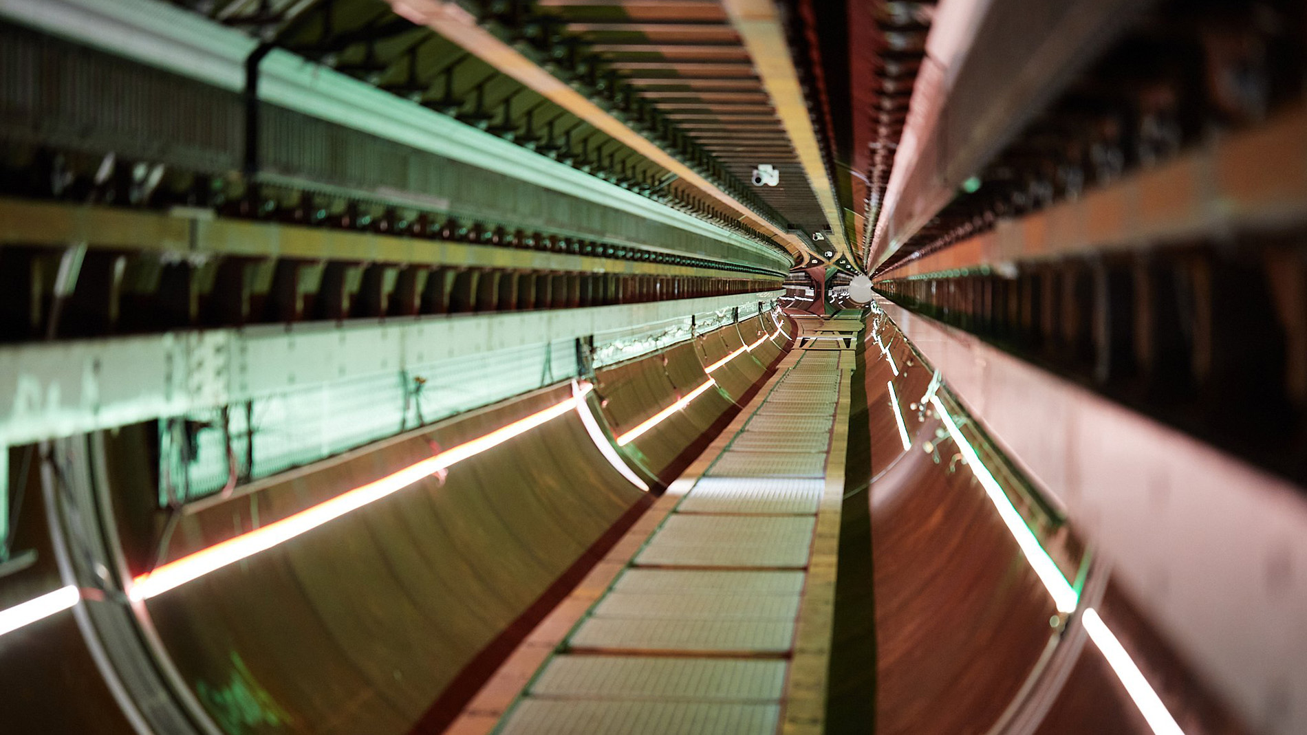 Light strips in alternating signal colours illuminate the concave walls of the Hyperloop tube