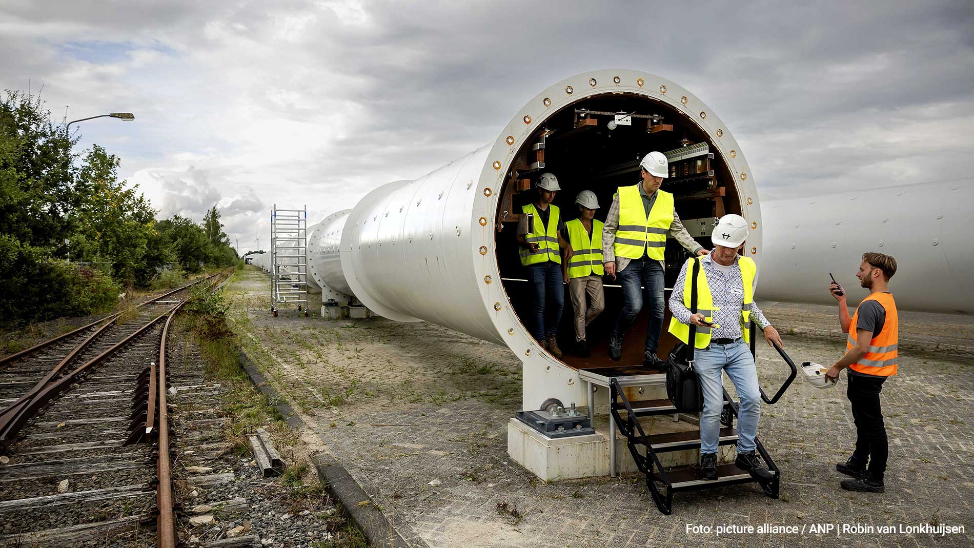Men come out of the Hyperloop tube