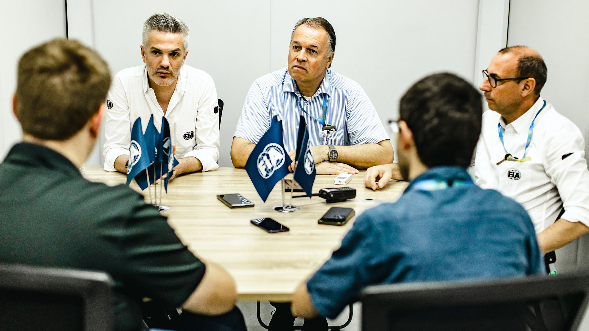 Five men are sitting at a table