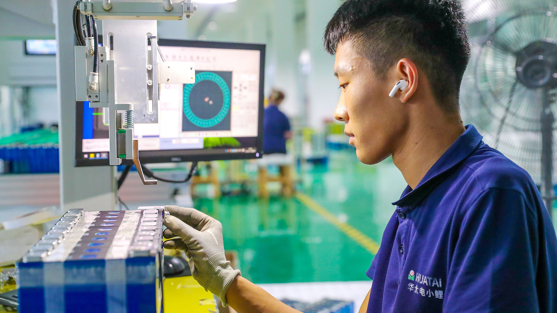Arbeiter montiert Lithium-Ionen-Batterien in moderner Fabrik.