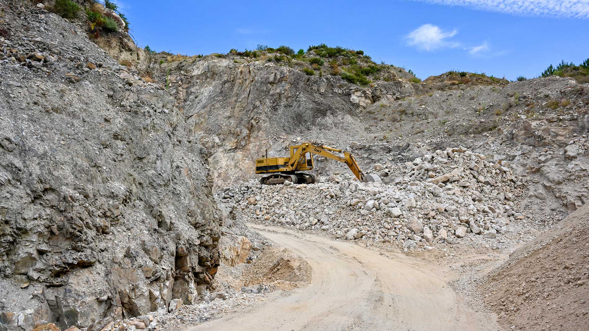 Bagger im Lithium-Bergwerk baut wertvolles Mineral für Batterien ab.