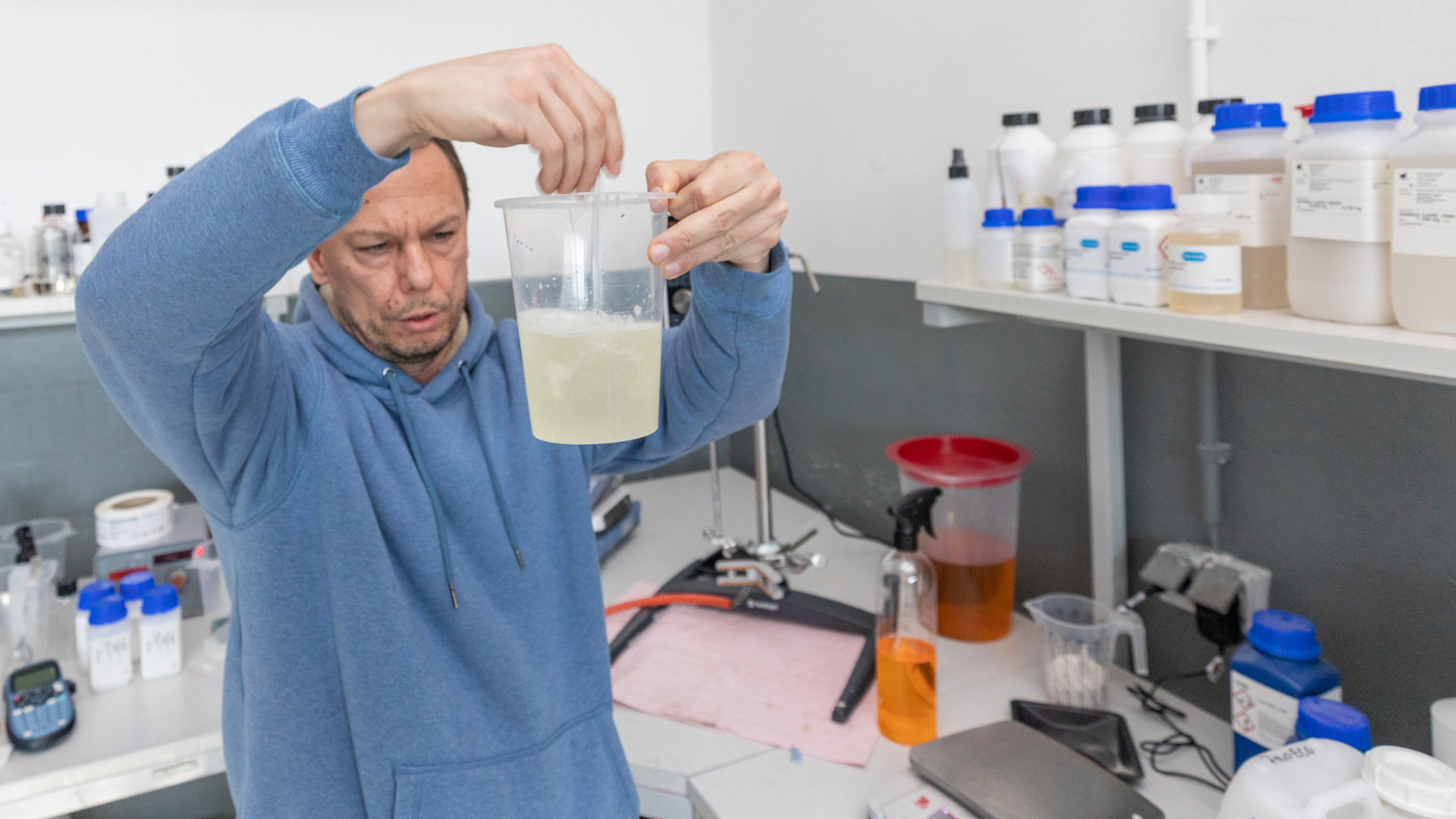 Man in a laboratory stirring something in a beaker