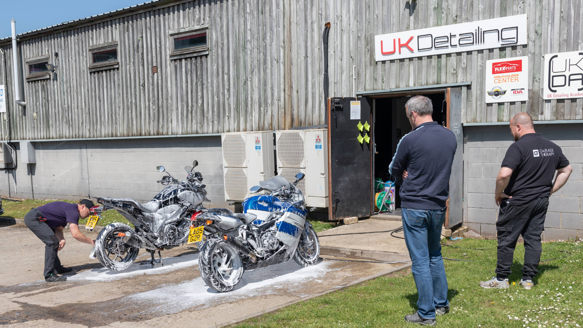 Men and motorbikes in front of a UKDetailing Shop