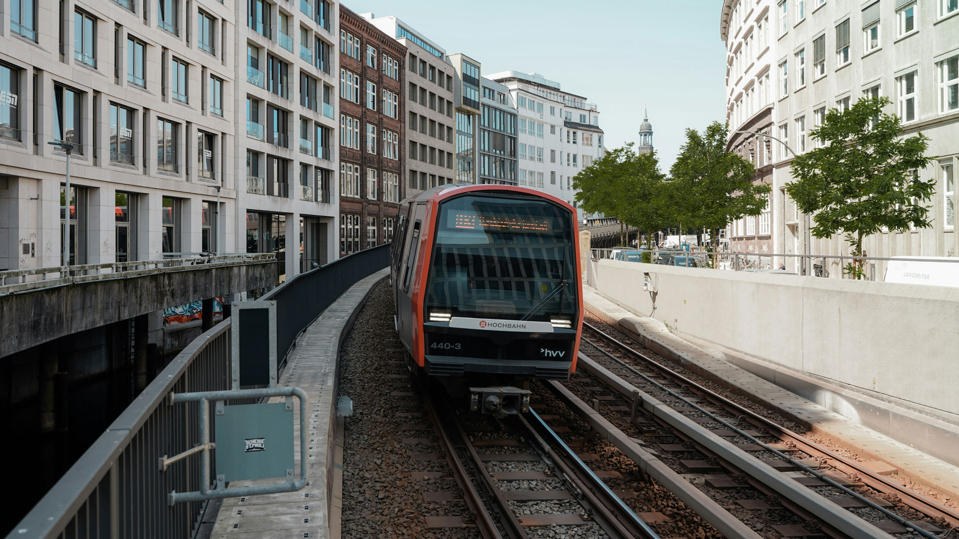ubway train by Hochbahn passing through modern city centre with office buildings