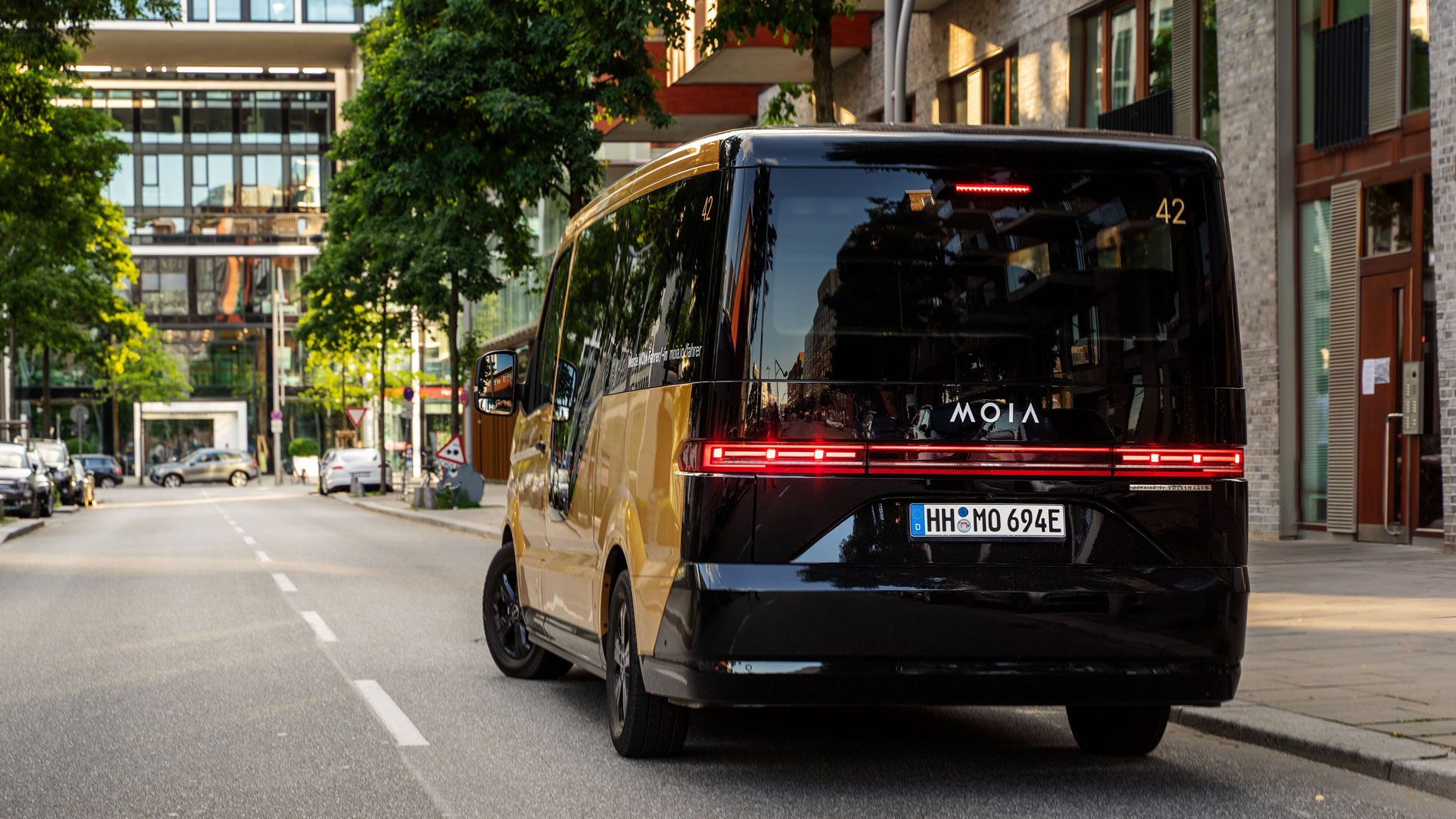 Rear view of Moia shuttle on street between modern buildings