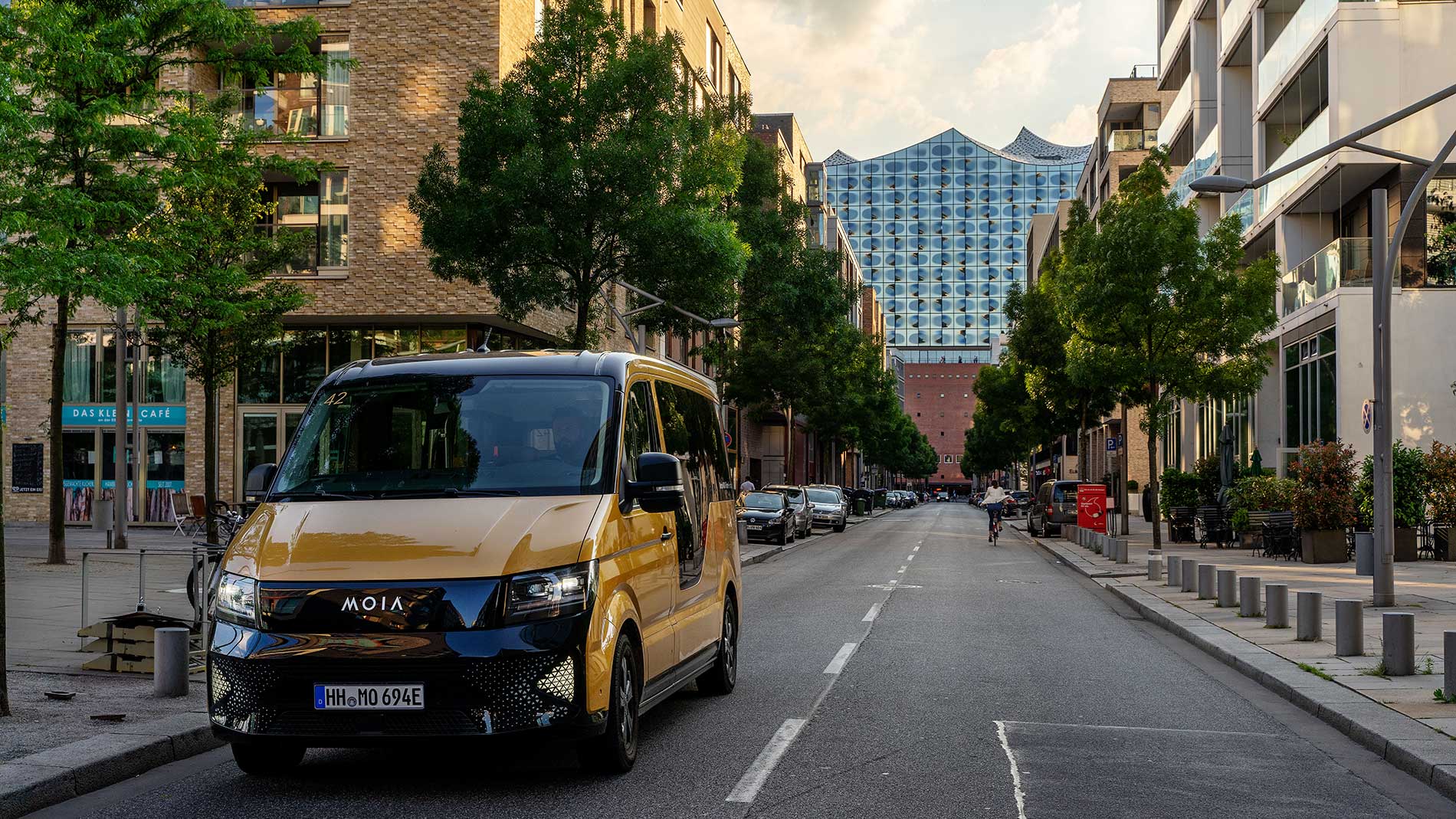 Moia shuttle driving through Hamburg city centre with Elbphilharmonie in background