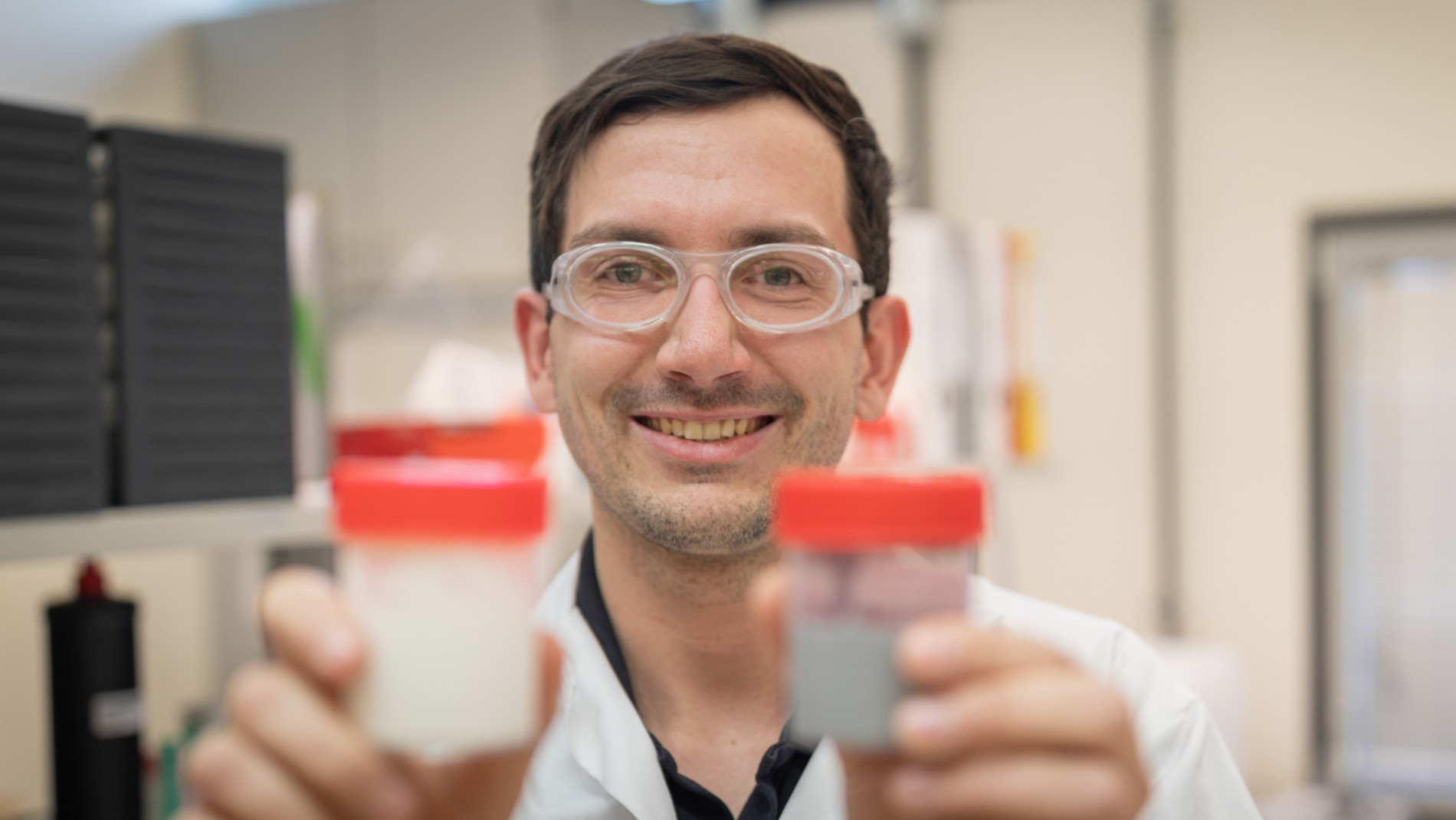 Wissenschaftler hält zwei Probenbecher