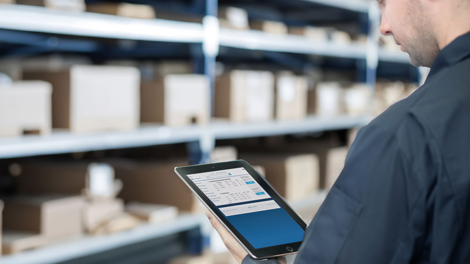 Employee scanning inventory with a tablet between shelves