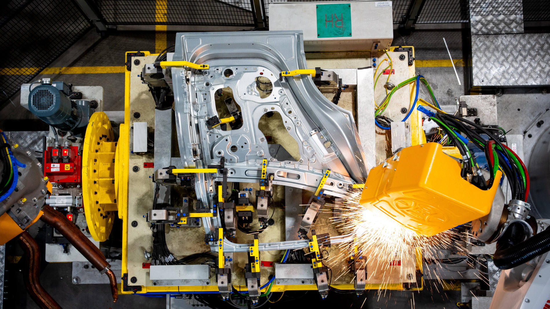 Robot welding a car body part with visible sparks