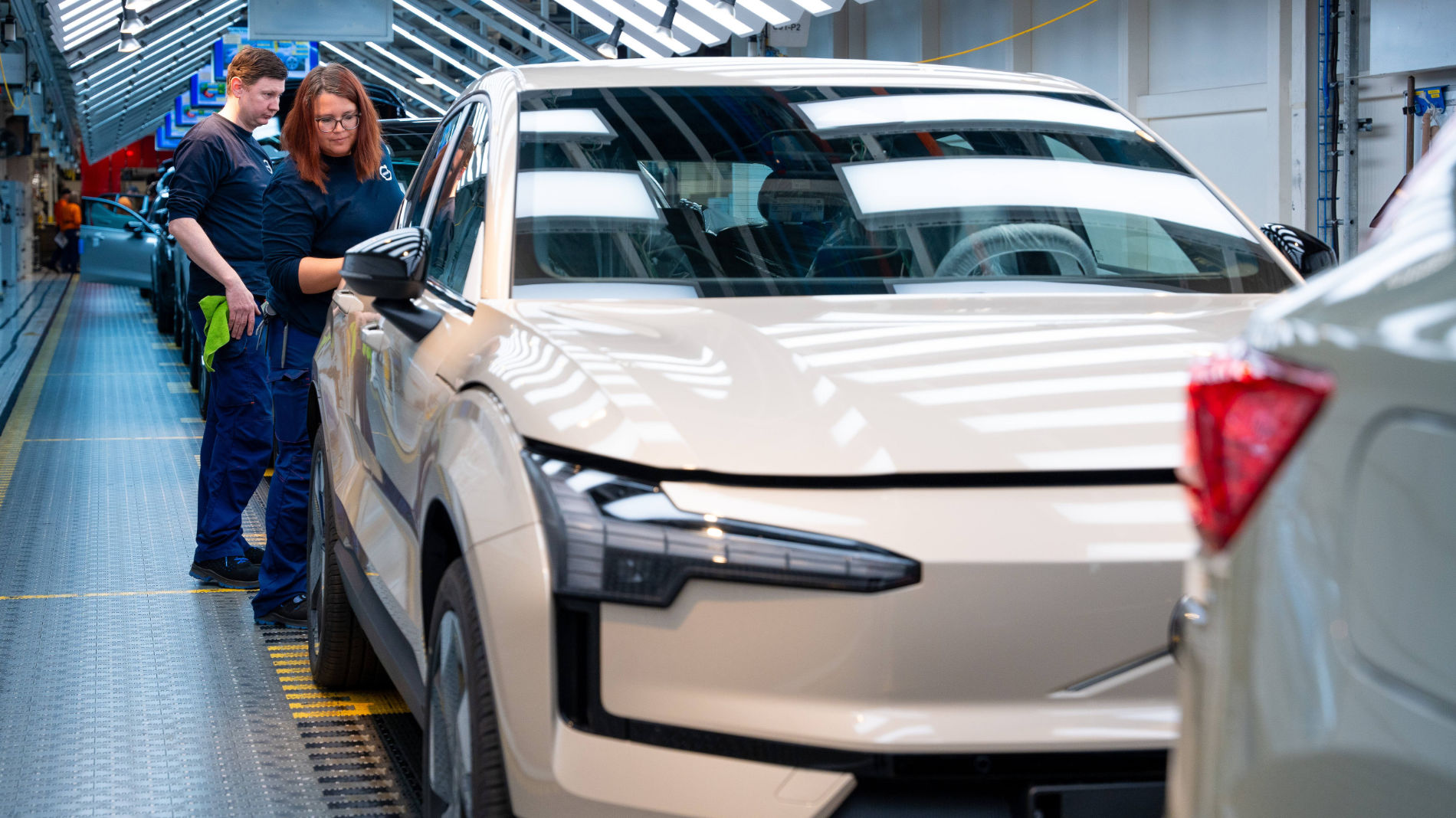 Employees inspecting a new electric vehicle on the production line at Volvo’s Ghent plant