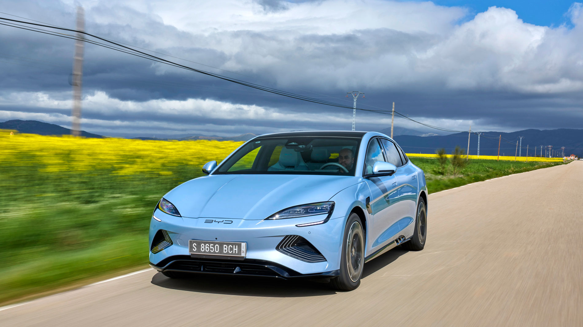 A light blue BYD Dolphin in the countryside