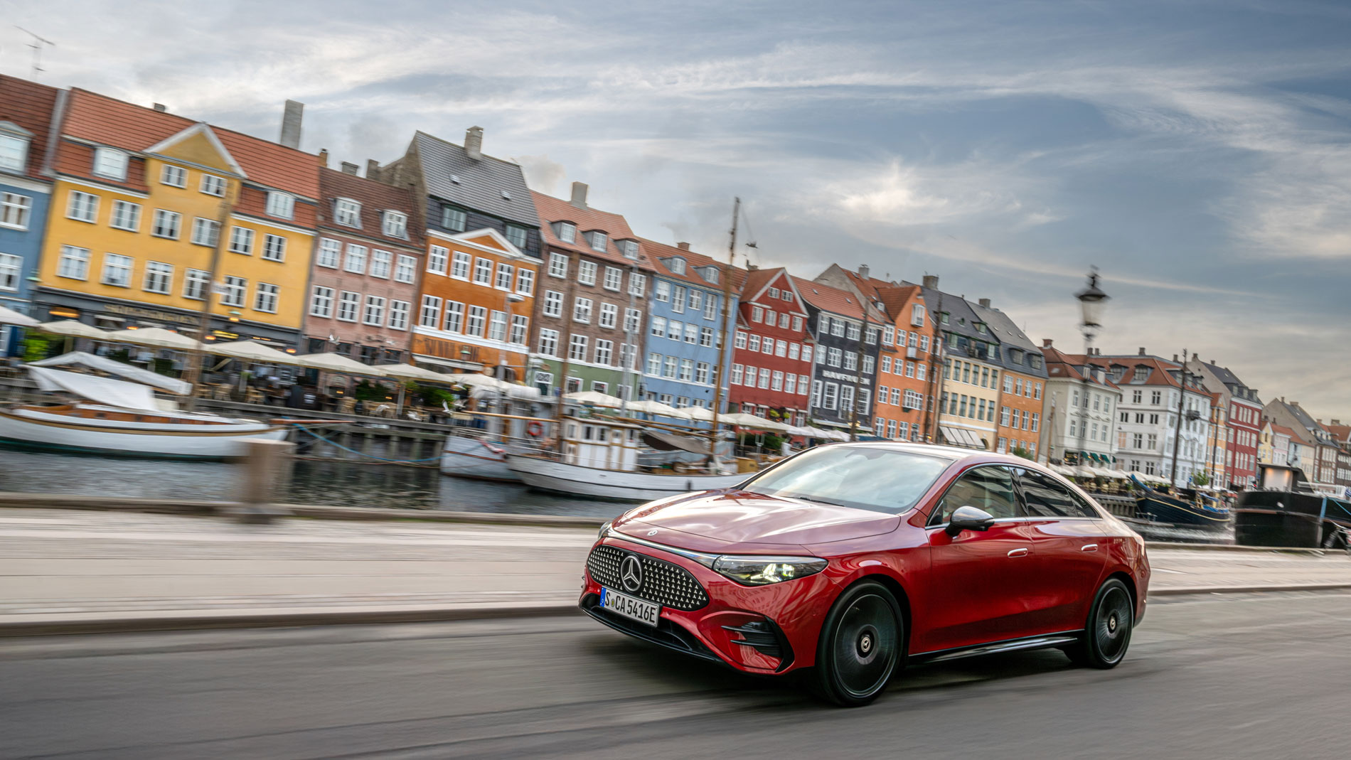 A red Mercedes CLA (electric) is driving around Copenhagen