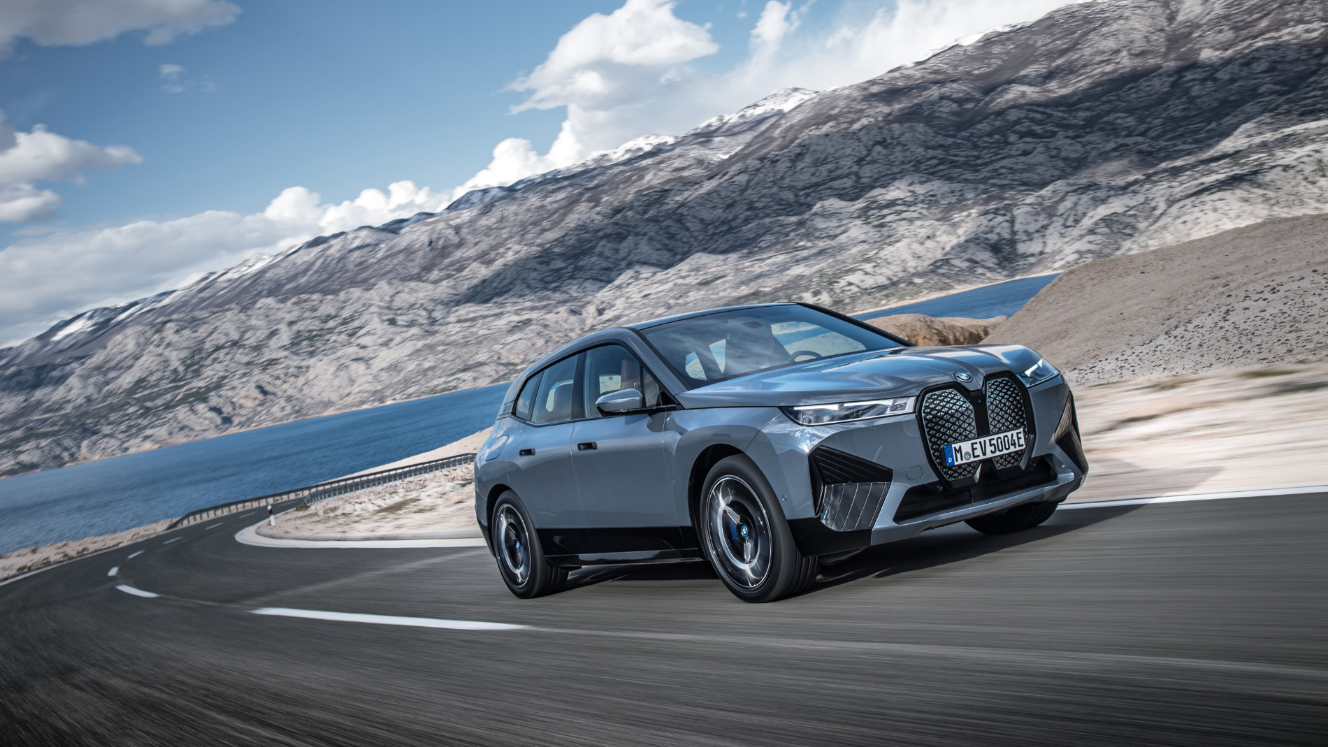 BMW iX electric SUV on winding coastal road