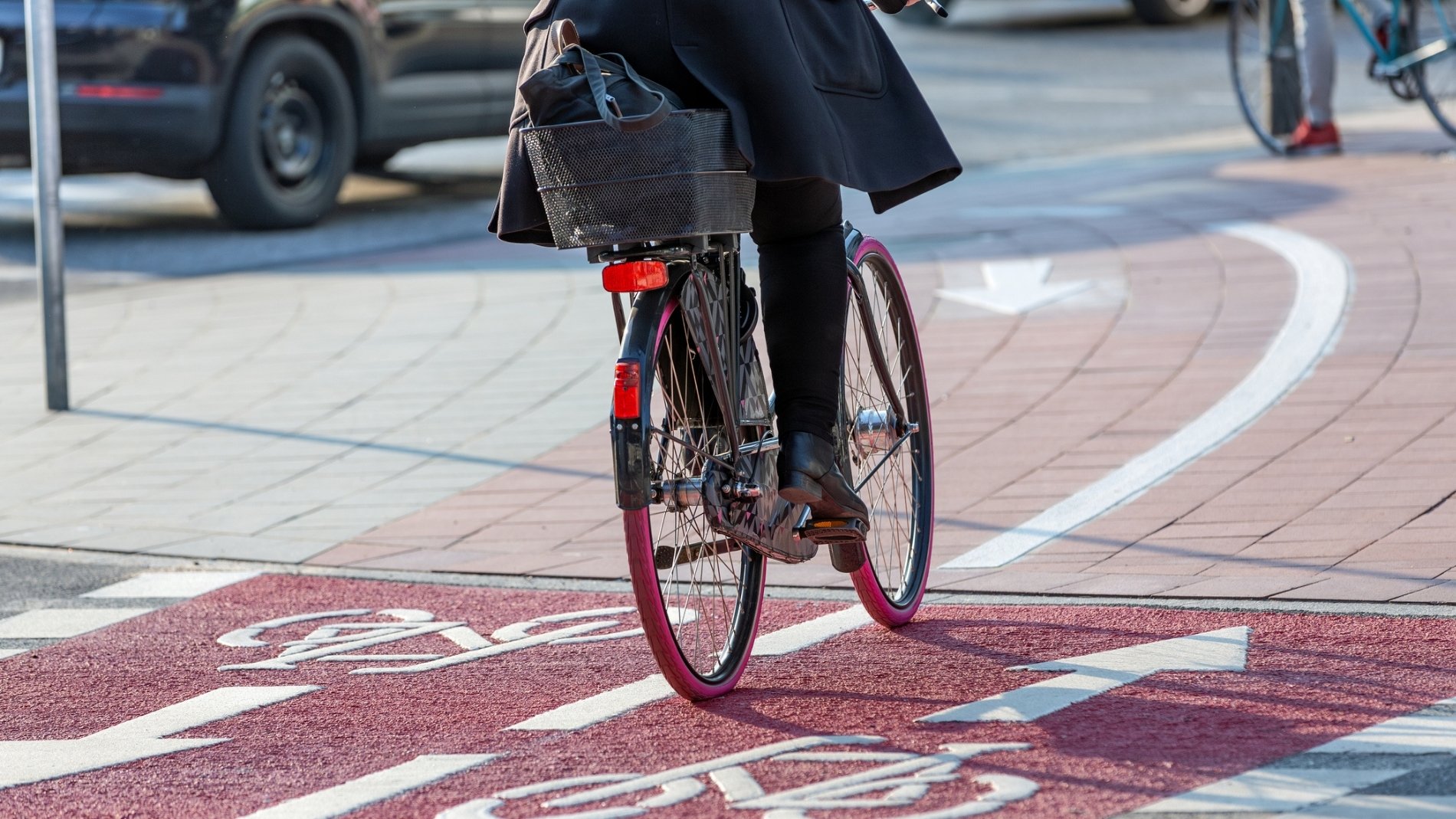 Radfahrer fährt auf markiertem roten Fahrradweg
