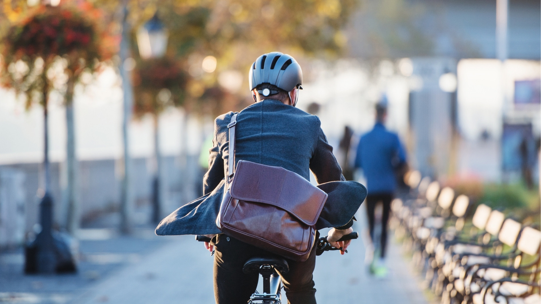 Pendler mit Rucksack fährt Fahrrad durch Park