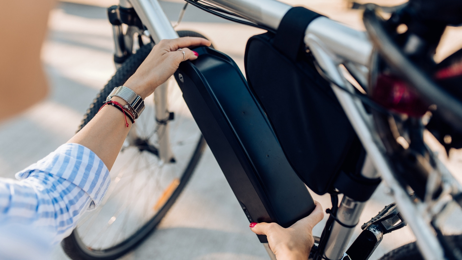 Hände setzen Akku an E-Bike Rahmen ein