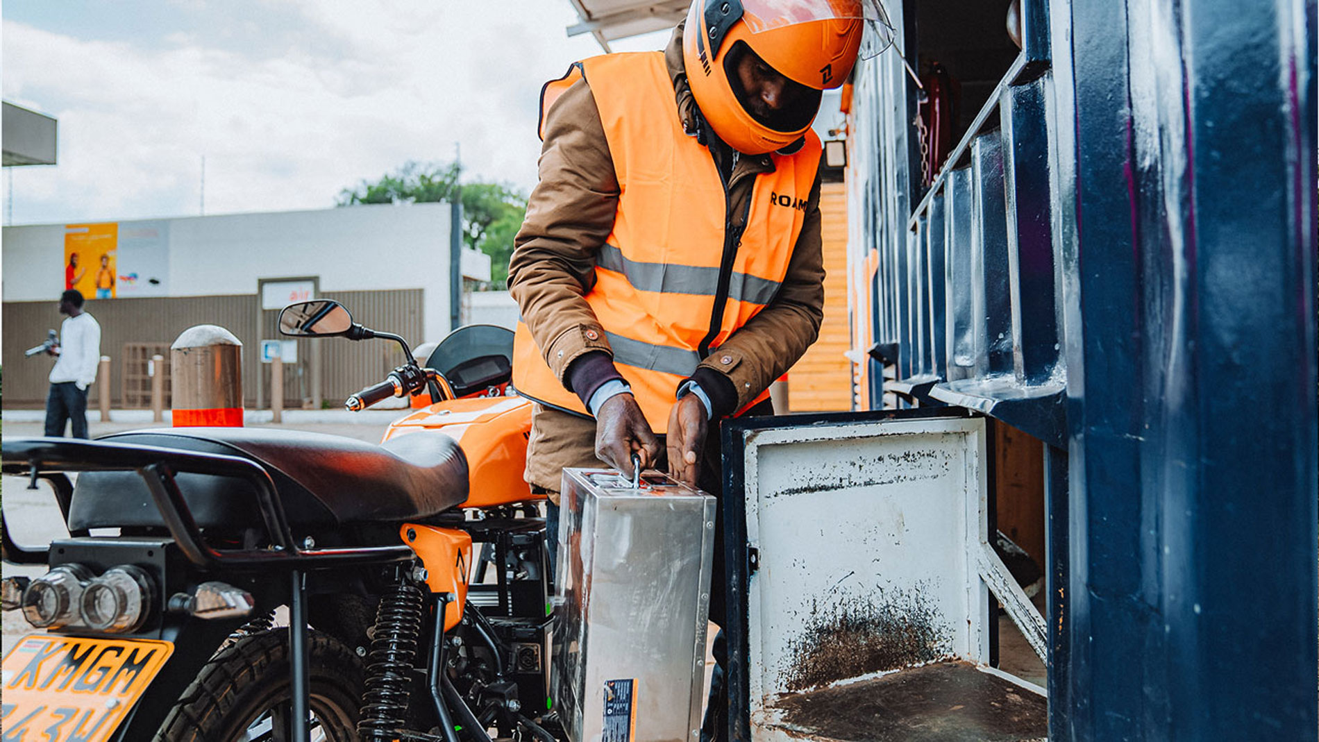 Rider replacing battery of an electric motorcycle at swapping station