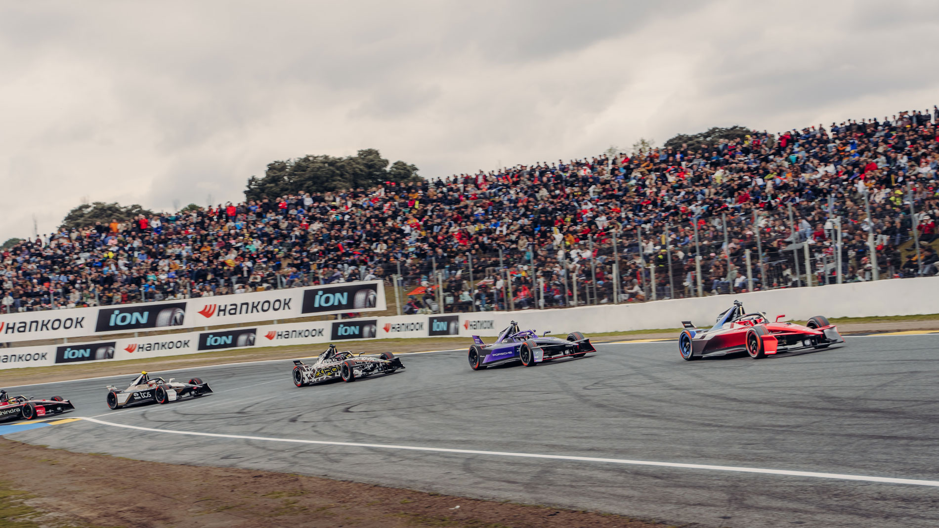 Formula E race cars before packed grandstand