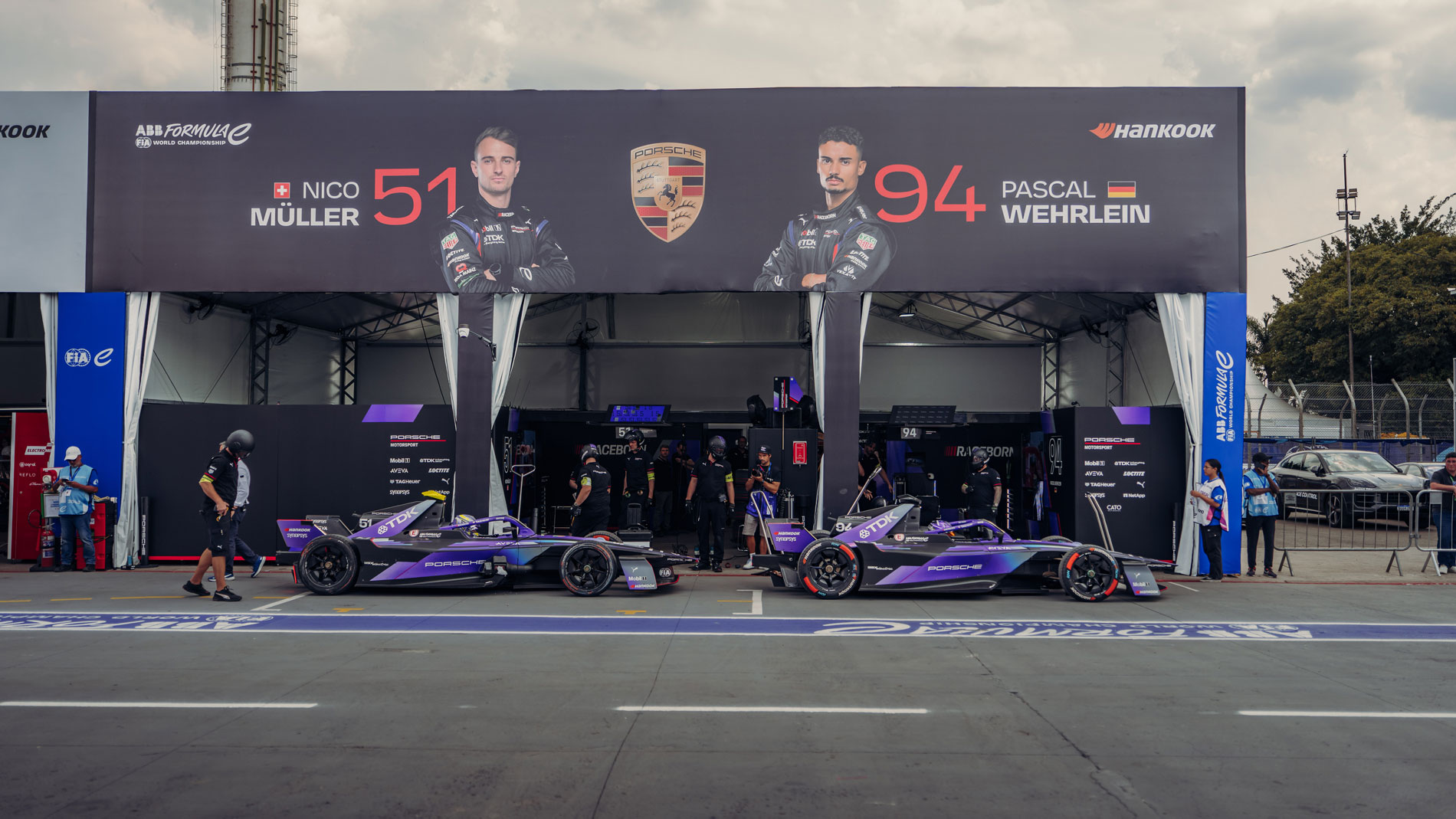 Porsche Formula E race cars outside team garage