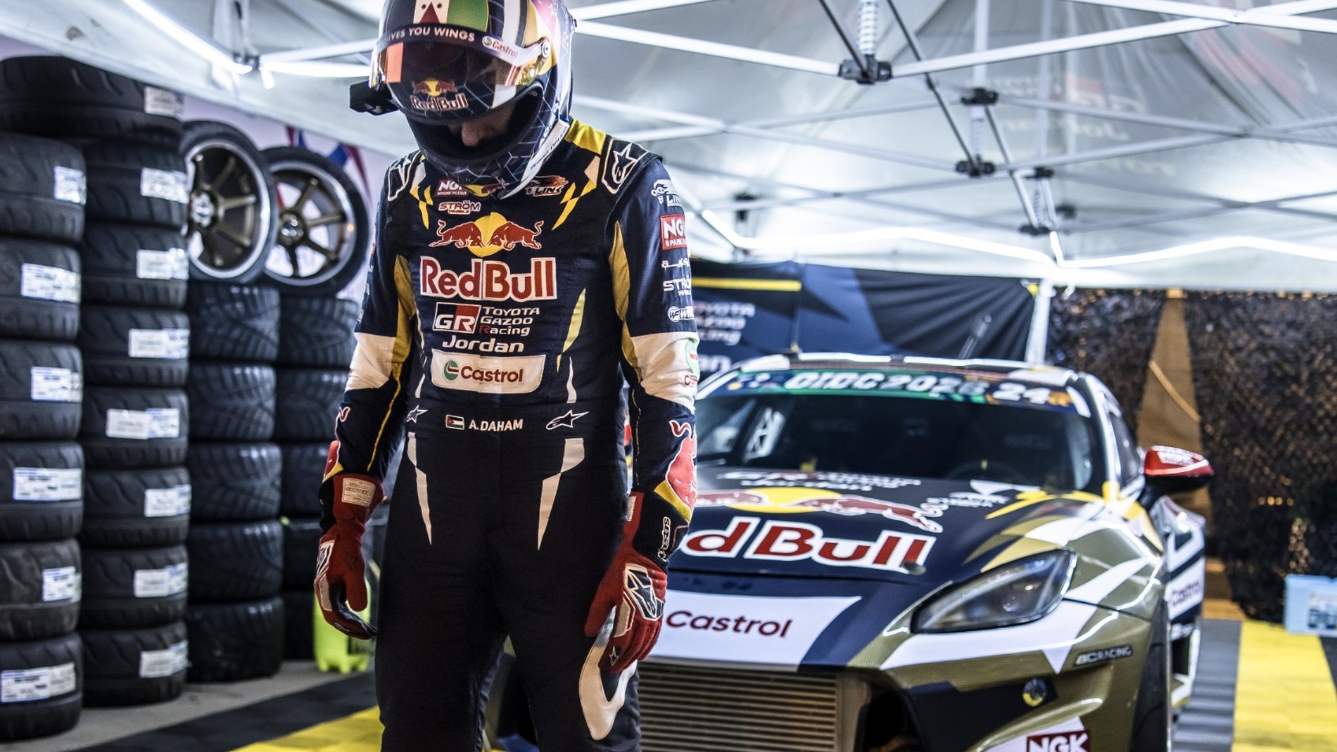 Rennfahrer im Teamzelt vor Drift-Rennwagen