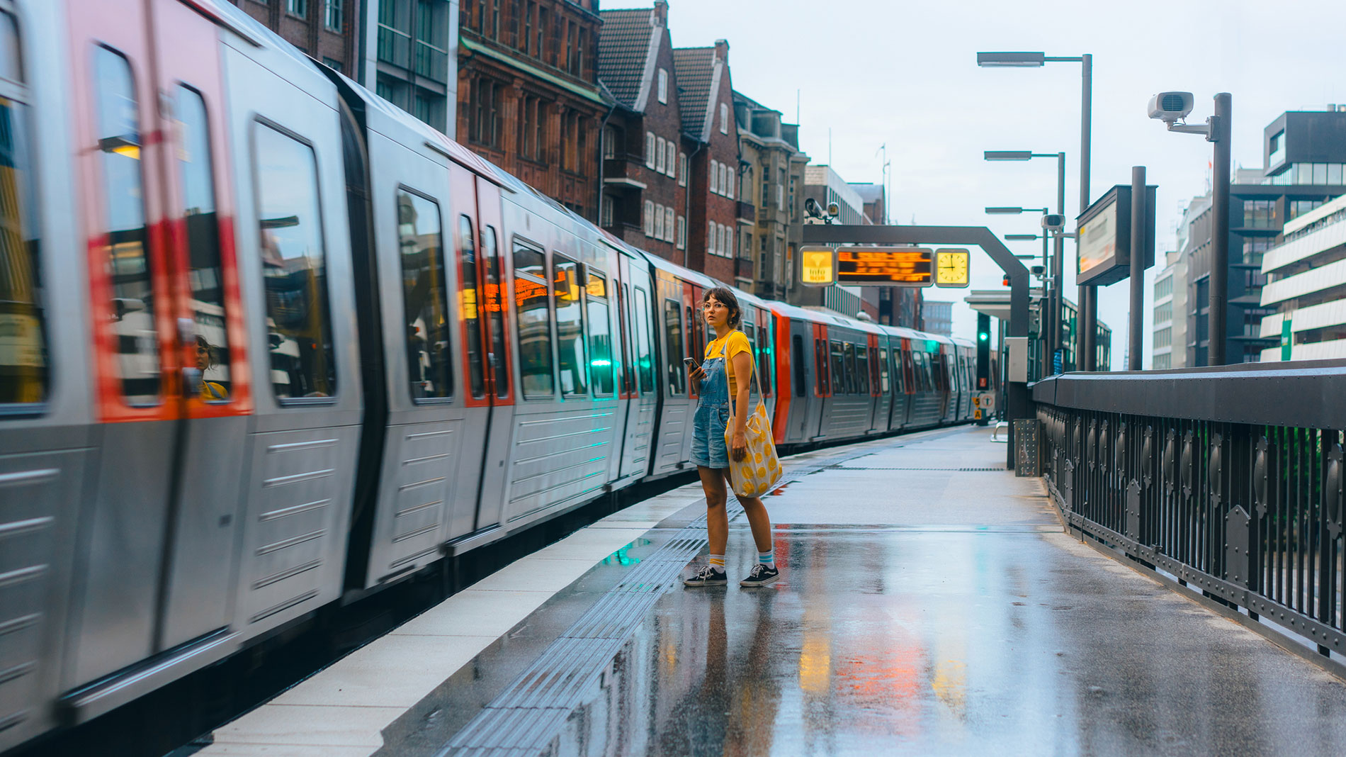 Frau wartet auf einfahrende U-Bahn am Bahnsteig