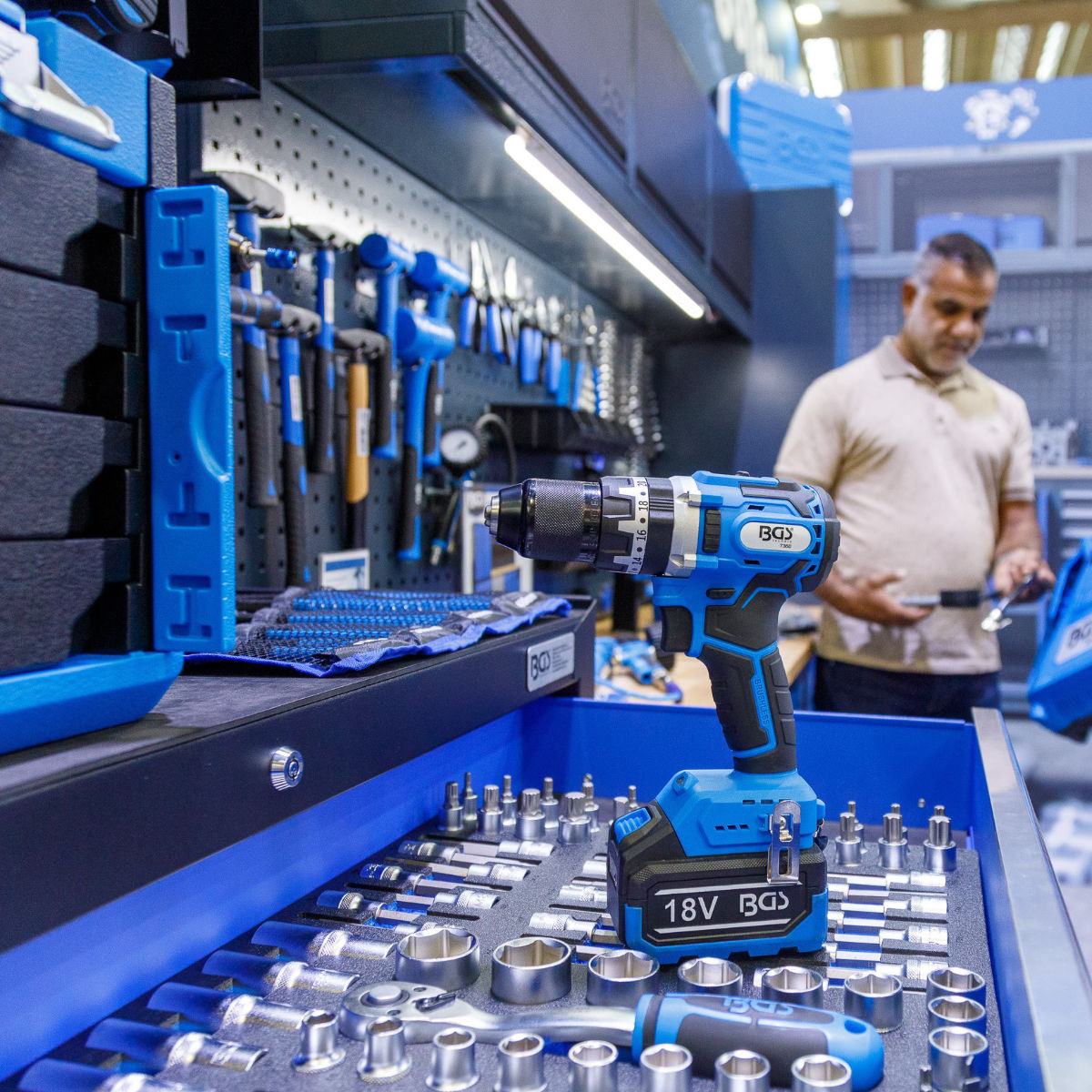 Moderne Werkstatt mit blauem Akkuschrauber und Werkzeugen – hochwertige Ausstattung für Handwerk und Industrie.